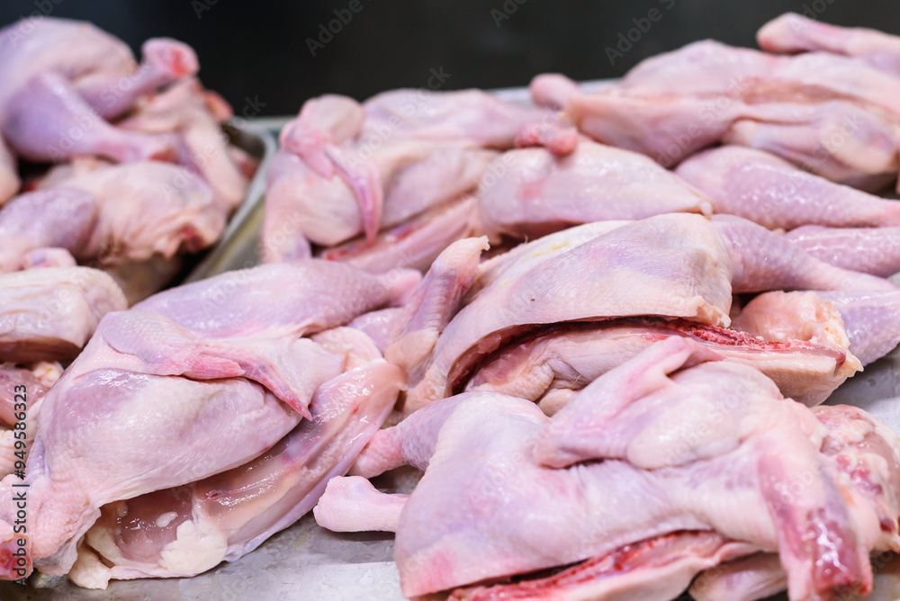 Raw Chicken Halves Split for Cooking on a Silver Tray with a Black Background Raw Chicken Halves Split for Cooking on a Silver Tray with a Black Background