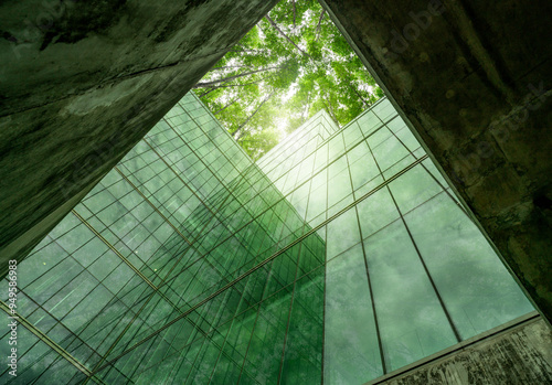 Eco-friendly building in modern city. Sustainable glass office structure with integrated greenery to reduce heat and carbon dioxide. Corporate architecture. Reducing CO2 emissions. Green environment. photo