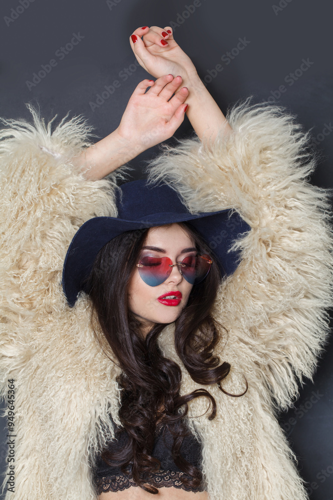 Dancing fashion model woman in blue classic hat and white fur coat posing indoor, elegance fashion beauty portrait