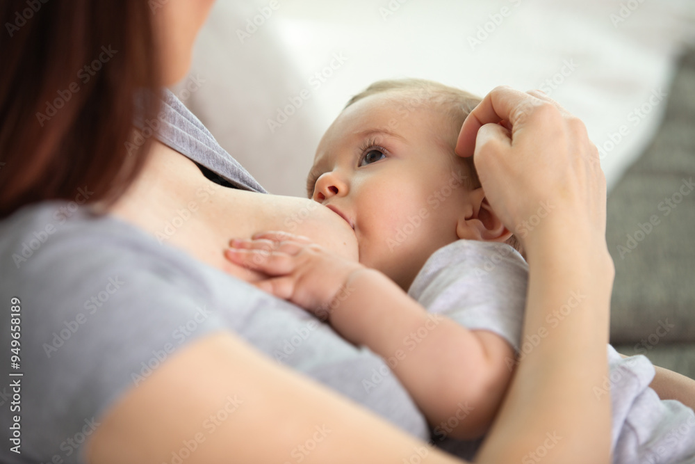 a woman breastfeeding her baby on light background a woman breastfeeding her baby on light background