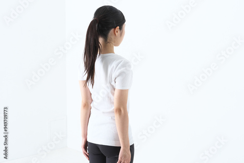 後ろ姿のTシャスにスパッツ姿の20代の女性