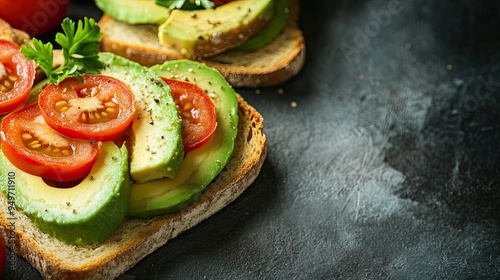 Toasted sourdough bread topped with creamy avocado slices and fresh tomato, set on a rustic surface with ample copy space