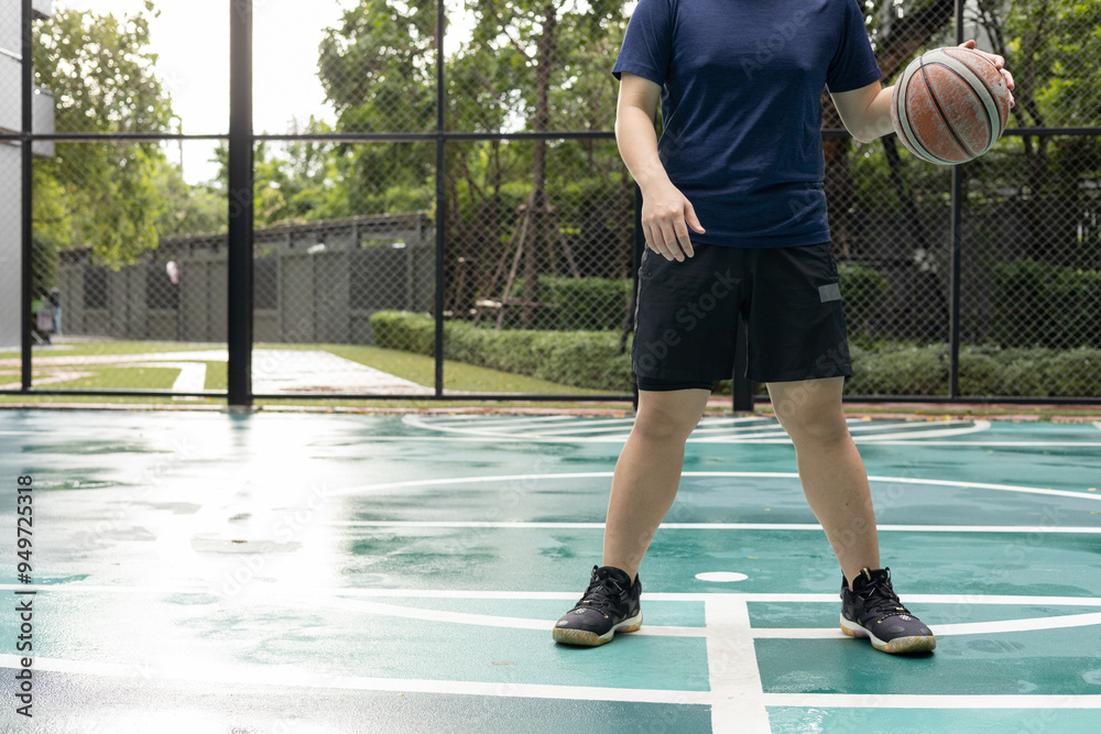 A man plays basketball while sitting on the court. A man plays basketball while sitting on the court.