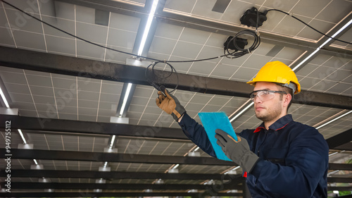 Engineer technical service checking solar panel while monitoring the system of solar panel on his tablet to make sure that's it work properly