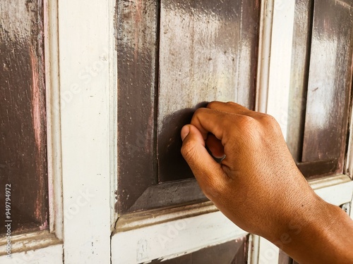 Close up of a man's hand knocking on the door