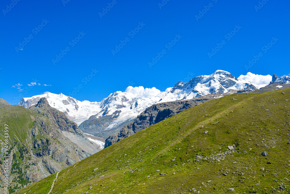 Swiss Alps peaks and ridges covered in snow in Summer. Stunning mountain landscape in Switzerland. Panoramic shot. Space for copy. Swiss Alps peaks and ridges covered in snow in Summer. Stunning mountain landscape in Switzerland. Panoramic shot. Space for copy.