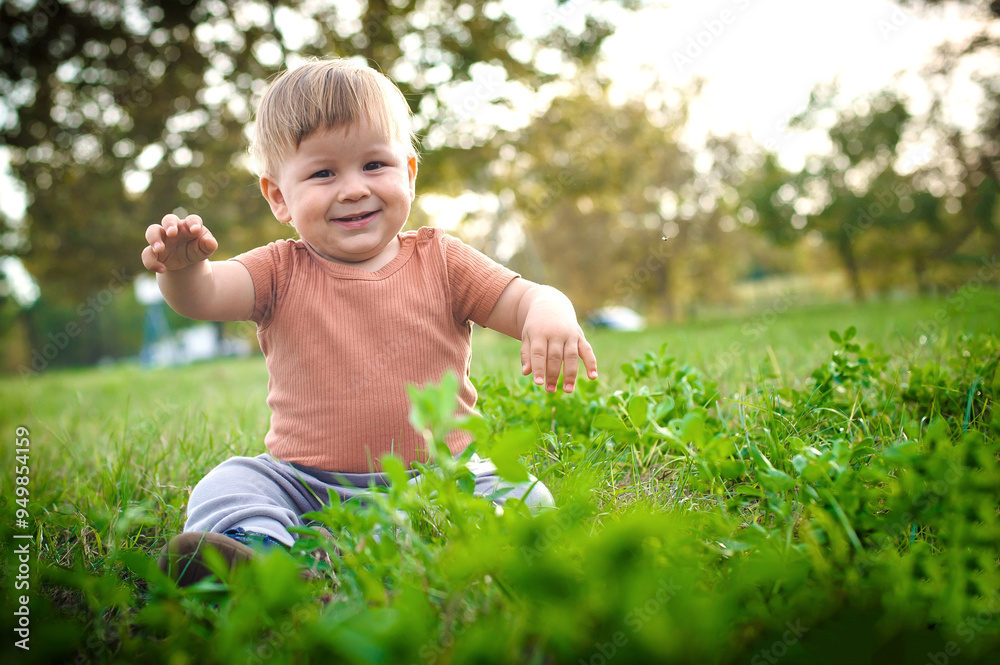 A joyful toddler plays in a grassy park on a sunny day, exploring the world around him with curiosity and delight A joyful toddler plays in a grassy park on a sunny day, exploring the world around him with curiosity and delight