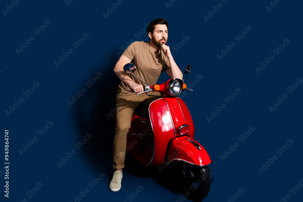 Photo of happy young man in beige t shirt likes summertime stop his transport moped looking novelty isolated on dark blue color background Photo of happy young man in beige t shirt likes summertime stop his transport moped looking novelty isolated on dark blue color background