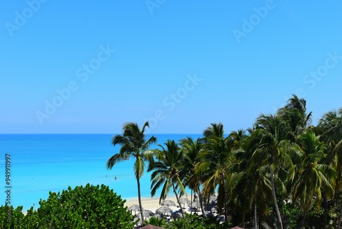 Varadero, CUBA - April 08, 2023:  Wide angle shot of beautiful beach on a hot summer day in the Caribbean, in Varadero, Cuba. Empty beach, calm sea. photo