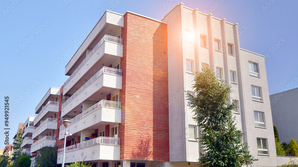 Fototapeta premium Low angle view apartment building from the beginning of the 21st century. Architectural elements of apartment building. Green surroundings of buildings. Ecological housing estate.