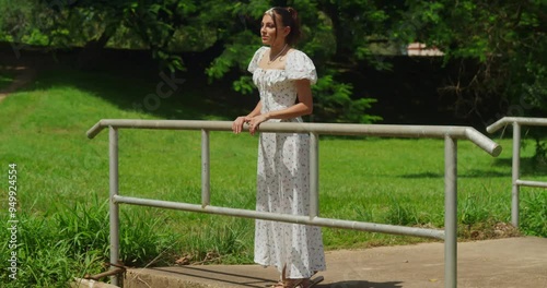 A girl in a breezy dress strolling in a sunlit tropical garden. photo