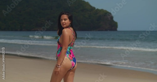 The tranquil beauty of a Caribbean beach captivates a girl in a bikini. photo