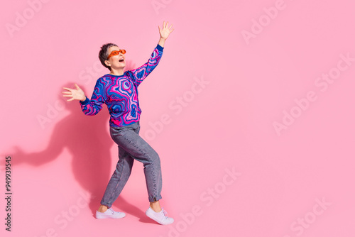 Full size photo of pretty retired female sunglass dancing have fun wear blue colorful outfit isolated on pink color background