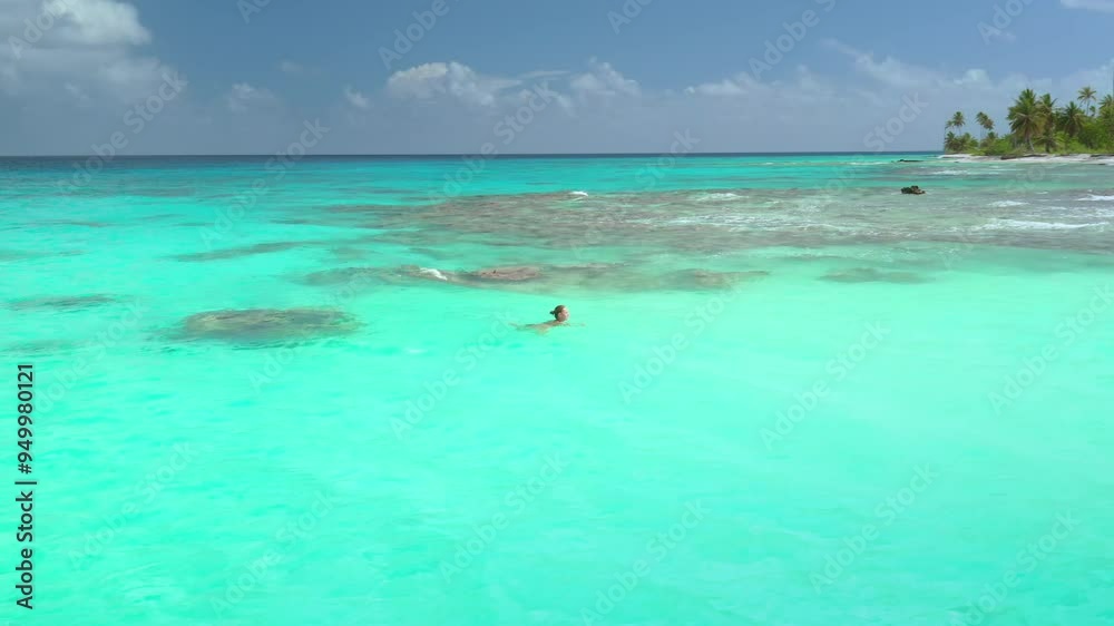 Woman swimming in the turquoise lagoon of rangiroa atoll, french polynesia. Concept of exotic vacations and enjoying the beauty of nature Woman swimming in the turquoise lagoon of rangiroa atoll, french polynesia. Concept of exotic vacations and enjoying the beauty of nature