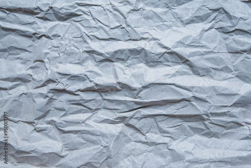 Wrinkled or crumpled grey packing paper background with noise or grain. Grunge creased wrapping paper texture. Material recycling concept