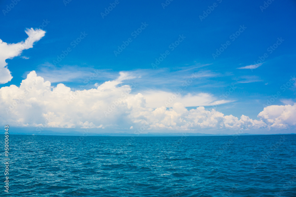 Obraz premium Blue sky with fluffy cloud in sea background