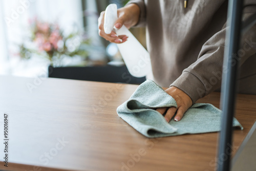 unknown woman clean the dust from shelves with dust and sprayer