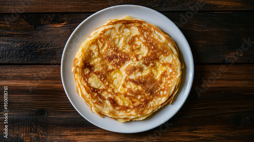 Stack of mouthwatering homemade pancakes on a white plate sitting on a dark wooden table