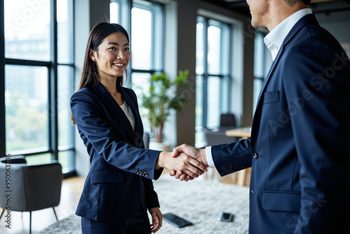 Successful Asian Businesswoman Shaking Hands with Male Executive: Perfect for Career Advancement Campaigns photo