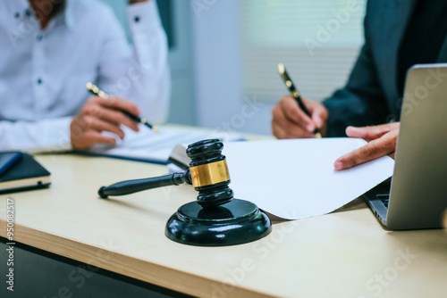 Two lawyers consult in a modern office, presenting compelling arguments and demonstrating their expertise, trying to win a case with their legal acumen and persuasive skills.
 photo