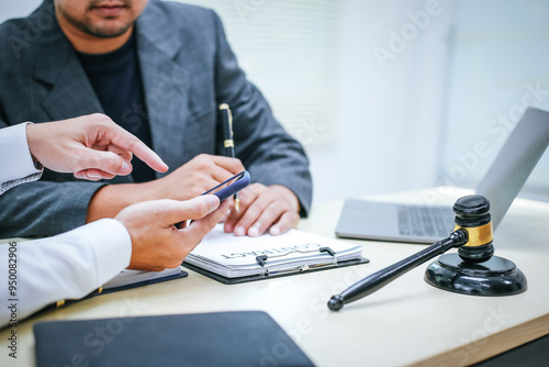 Two lawyers consult in a modern office, presenting compelling arguments and demonstrating their expertise, trying to win a case with their legal acumen and persuasive skills.
 photo