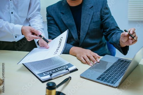 Two lawyers consult in a modern office, presenting compelling arguments and demonstrating their expertise, trying to win a case with their legal acumen and persuasive skills.
 photo