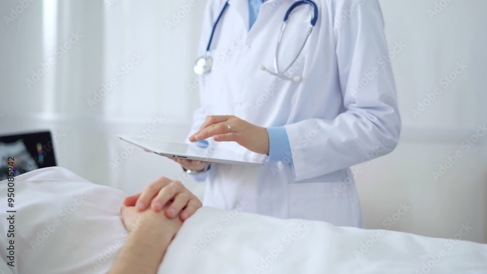 Doctor consulting patient with digital tablet in hospital room. Healthcare professional providing care