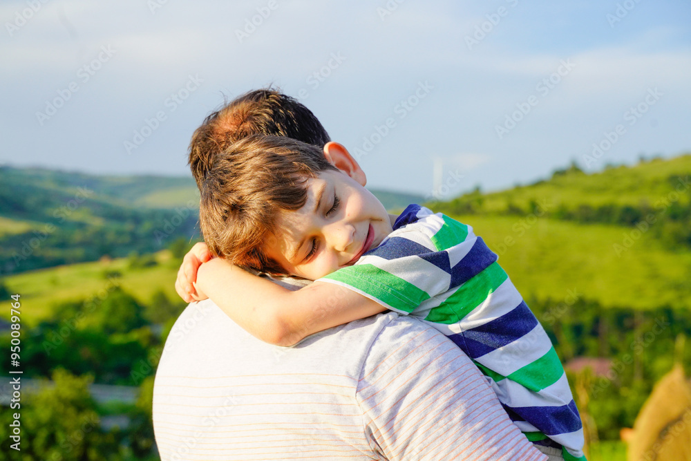 Father and son enjoying sunset at the meadow in mountains Father and son enjoying sunset at the meadow in mountains