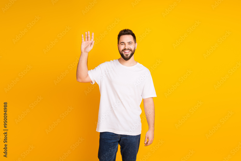 Photo portrait of handsome young guy wave hand hi dressed stylish white garment isolated on yellow color background Photo portrait of handsome young guy wave hand hi dressed stylish white garment isolated on yellow color background