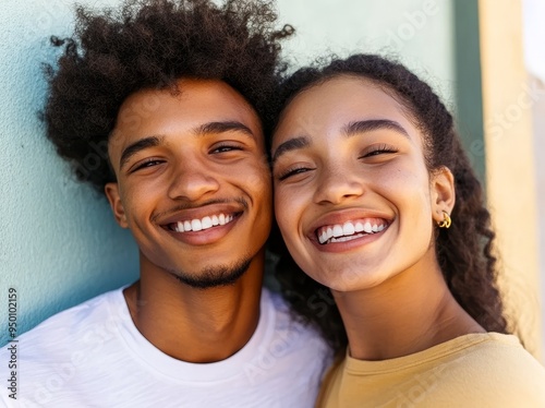 A beautiful girl and her handsome boyfriend taking selfie self portrait of themselves on their smartphone camera. Having fun on a street background.