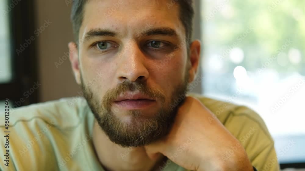 The man's hands take French fries and eats it. Close up view. Young bearded man eats fast food in cafe The man's hands take French fries and eats it. Close up view. Young bearded man eats fast food in cafe