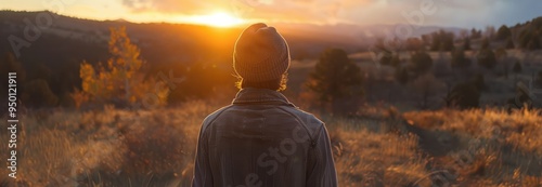 Silhouette of a Person Watching the Sunset Over a Mountain Range