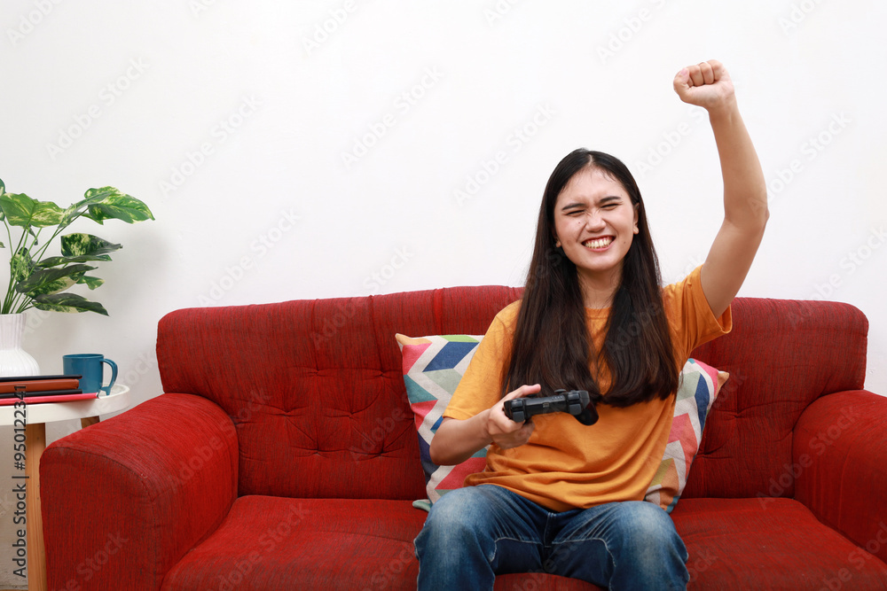 Leisure activities. Young positive happy asian girl holding joystick playing video game while resting at home, sitting in casual clothes on comfortable sofa in cozy living room Leisure activities. Young positive happy asian girl holding joystick playing video game while resting at home, sitting in casual clothes on comfortable sofa in cozy living room