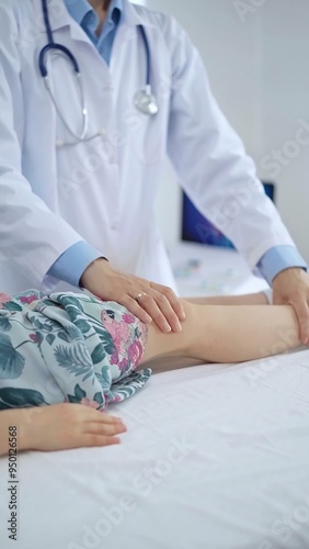 Doctor and kid patient. Orthopedist examining girl's knee in medical clinic. Medicine and health care photo