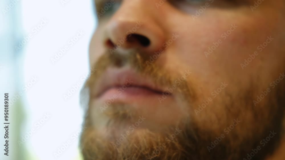 A young handsome bearded man is sitting in a cafe and eating delicious crispy cookies, a close-up view. A thoughtful guy is munching on sweet pastries A young handsome bearded man is sitting in a cafe and eating delicious crispy cookies, a close-up view. A thoughtful guy is munching on sweet pastries