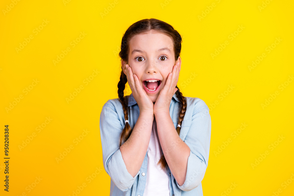 Photo of charming cheerful glad girl wear trendy denim clothes wow sale isolated on yellow color background Photo of charming cheerful glad girl wear trendy denim clothes wow sale isolated on yellow color background