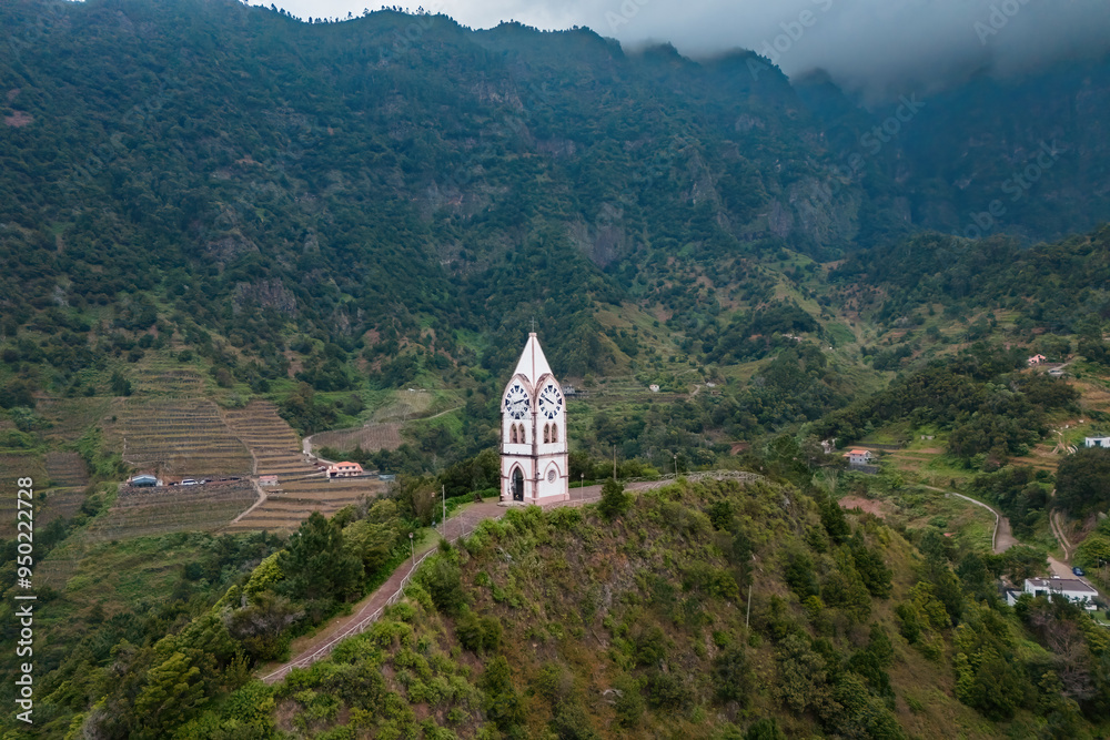 Clock tower of chapel of our Lady of Fatima in background In Sao Vicente on Madeira island, Portugal. Aerial view Clock tower of chapel of our Lady of Fatima in background In Sao Vicente on Madeira island, Portugal. Aerial view