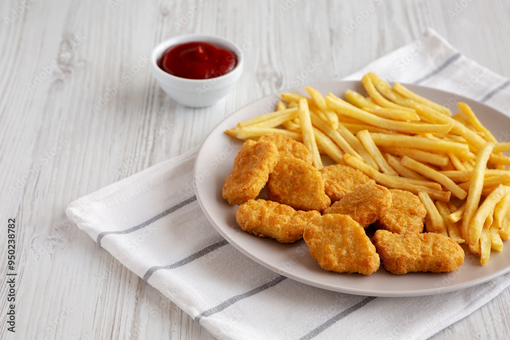 Fried Chicken Nuggets with French Fries on a Plate, side view. Copy space. Fried Chicken Nuggets with French Fries on a Plate, side view. Copy space.