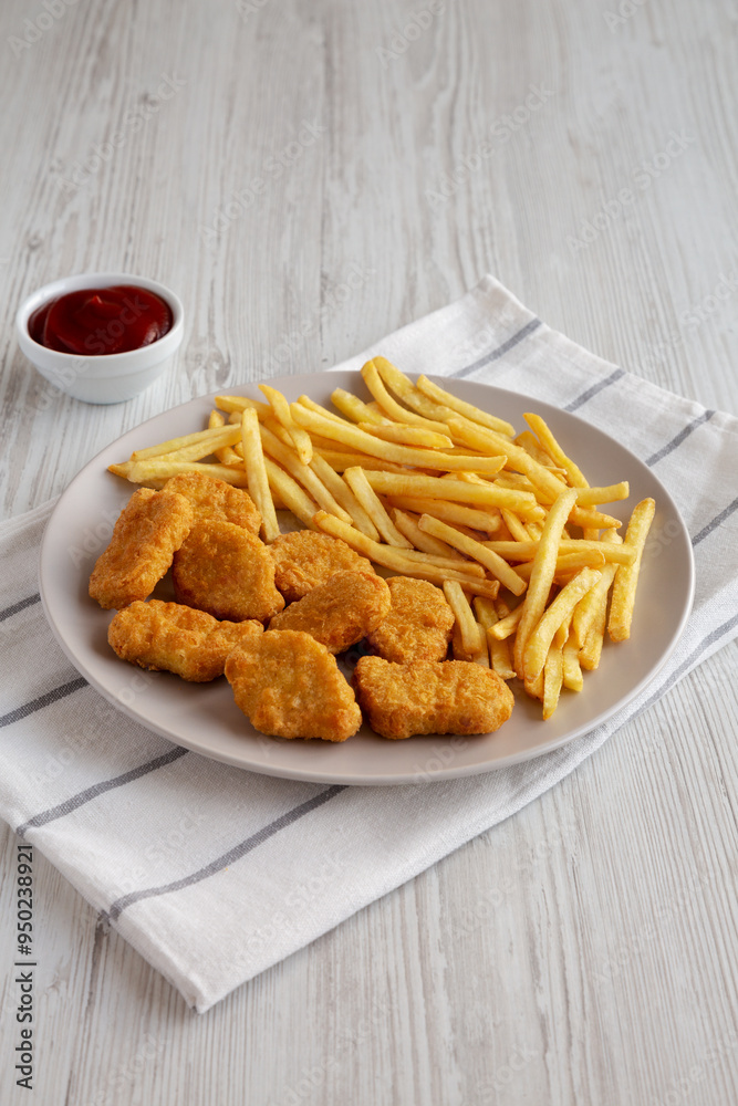 Fried Chicken Nuggets with French Fries on a Plate, side view. Fried Chicken Nuggets with French Fries on a Plate, side view.