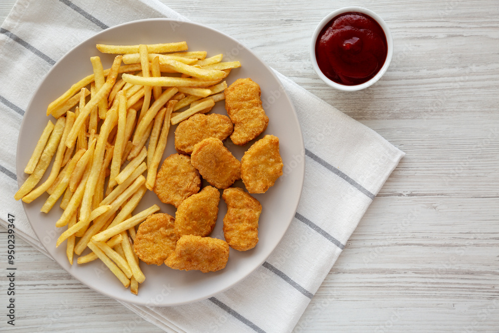 Fried Chicken Nuggets with French Fries on a Plate, top view. Overhead, from above, flat lay. Fried Chicken Nuggets with French Fries on a Plate, top view. Overhead, from above, flat lay.