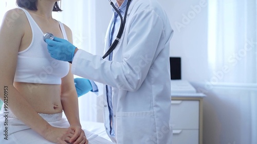 Doctor and patient. Physician wearing blue medical gloves is using stethoscope examining woman lungs in clinic. Medicine concept