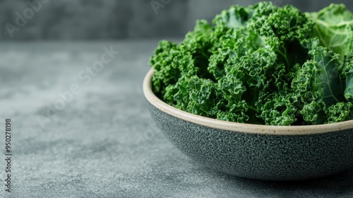 A bowl filled with fresh green kale leaves, set against a gray background, representing a healthy and nutritious food choice, perfect for salads and smoothies. photo