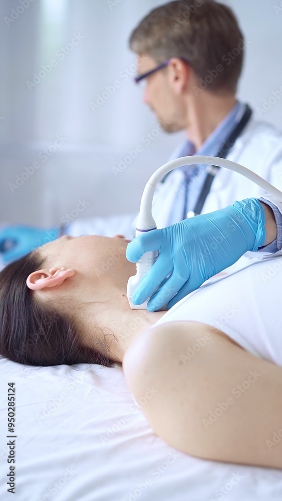 Fototapeta premium Doctor man wearing blue protective gloves is using ultrasound equipment on the neck of a patient woman, lying for examination. Medicine concept