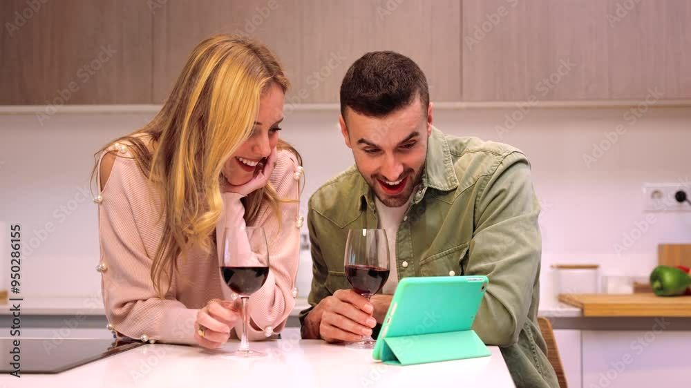 Couple at home looking at social media while drinking wine