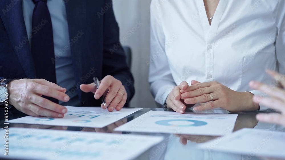 Business people wearing suits are reviewing a financial results and discussing the terms of the agreement. Teamwork and planning Business people wearing suits are reviewing a financial results and discussing the terms of the agreement. Teamwork and planning