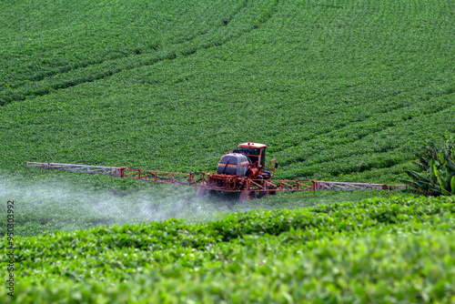 фотографія Tractor spraying fertilizer or pesticides on soybean field with sprayer in Brazi