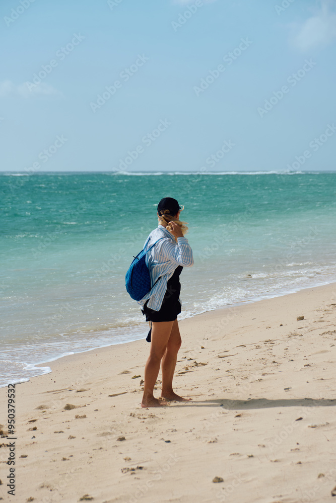 Beautiful woman is enjoying walking over the white sandy beach, tropical island, ocean bay Beautiful woman is enjoying walking over the white sandy beach, tropical island, ocean bay