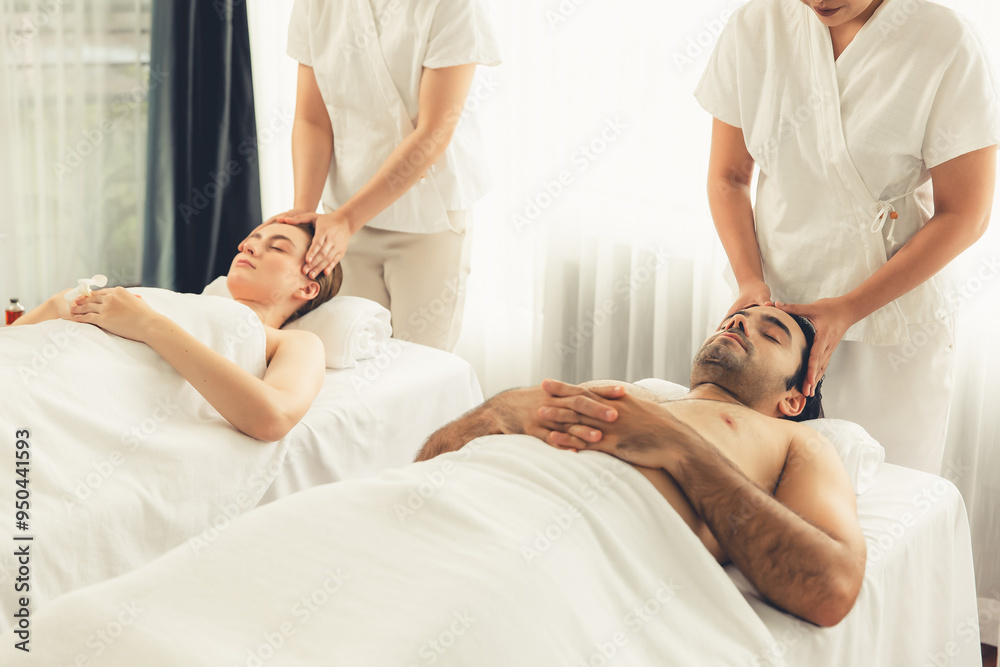 Obraz premium Caucasian couple enjoying relaxing anti-stress head massage and pampering facial beauty skin recreation leisure in dayspa modern light ambient at luxury resort or hotel spa salon. Quiescent
