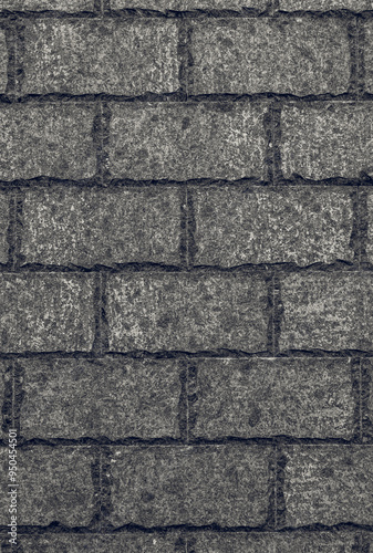 Stone wall made of rectangular blocks with decoratively hewn and processed edges in black and white. The stonework has a small pattern and an almost smooth relief. Monotonous neutral background. 