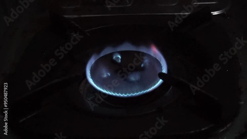 Close-up of a blue gas flame on a stovetop burner.